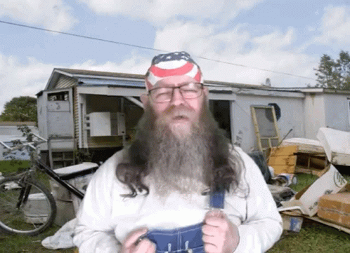 A Man With A Long Beard Wearing Overalls And A Headband With An American Flag On It GIF