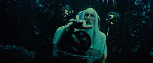 A Man With A Long White Beard Is Holding A Clock In His Hand . GIF