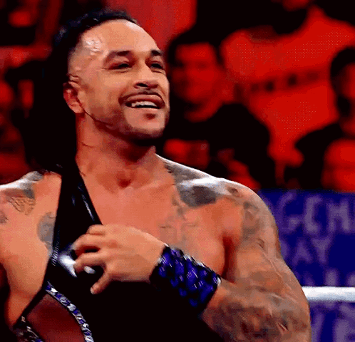 A Man With A Lot Of Tattoos Is Smiling In A Ring GIF