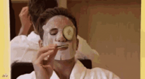 A Man With A Mask On His Face And A Cucumber On His Eye . GIF