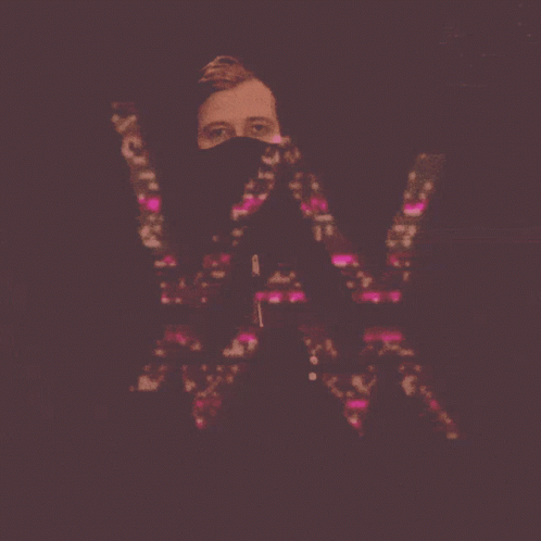 A Man With A Mask On His Face Holds The Letter W GIF