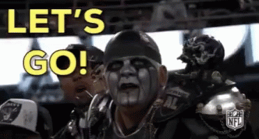 A Man With A Mask On His Face Is Sitting In A Stadium And Says Let 'S Go ! GIF