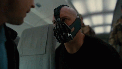 A Man With A Mask On His Face Talking To Another Man GIF