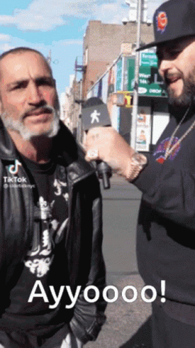 Man With Microphone Talking To Man With S Hat GIF