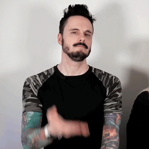 Man With Mohawk And Camo Sleeves Black Shirt GIF