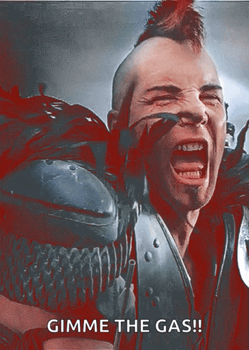 A Man With A Mohawk Is Screaming With The Words Gimme The Gas GIF