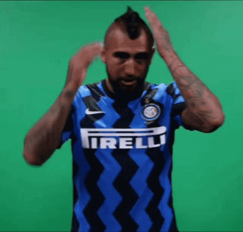 A Man With A Mohawk Is Wearing A Blue And Black Shirt With The Word Irelli On It GIF
