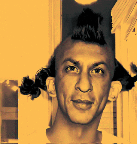 A Man With A Mohawk Looks At The Camera With A Yellow Background GIF