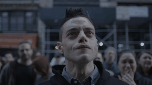 A Man With A Mohawk Looks Up At Something In The Sky GIF