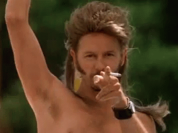 A Man With A Mullet And A Beard Is Smoking A Cigarette And Pointing . GIF