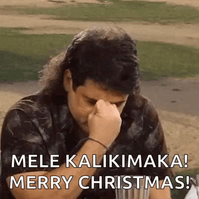 A Man With A Mullet Is Covering His Face With His Fist And Says Merry Christmas . GIF