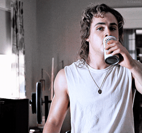 A Man With A Mullet Is Drinking From A Can That Says Budweiser On It GIF