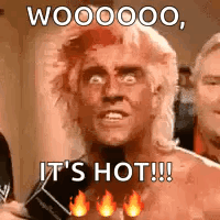 A Man With A Mullet Is Holding A Microphone And Says `` It 'S Hot ! '' GIF