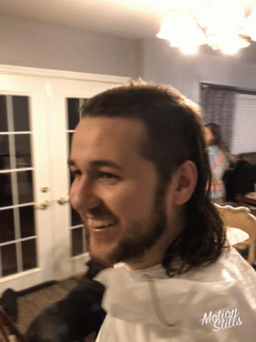 A Man With A Mullet Is Smiling In A Motion Stills Photo GIF