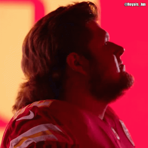A Man With A Mullet Is Wearing A Red Jersey With The Number 9 On It GIF