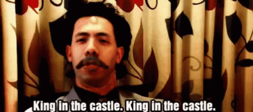 A Man With A Mustache And A Hat Is Standing In Front Of A Curtain And Says King In The Castle . GIF