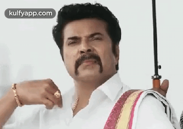 A Man With A Mustache And A Ring Is Holding An Umbrella . GIF