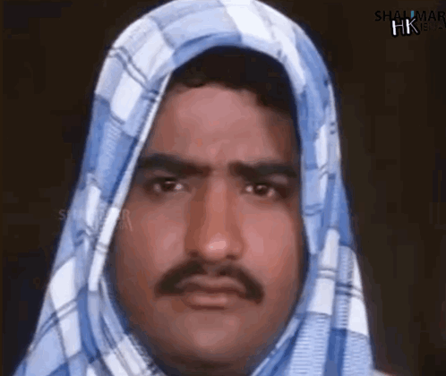 A Man With A Mustache And A Scarf Around His Head . GIF