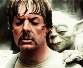 A Man With A Mustache And A Statue Of Yoda On His Back GIF