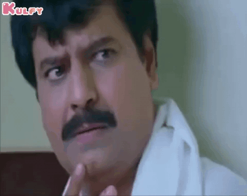 A Man With A Mustache And A White Shirt Is Making A Funny Face While Smoking A Cigarette . GIF