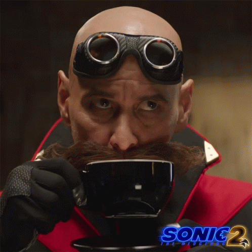 a man with a mustache and goggles is drinking from a cup with sonic 2 written on the bottom