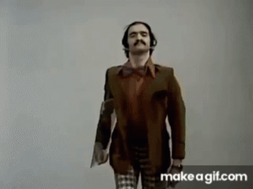 a man with a mustache and headphones is standing next to a woman in a plaid shirt .