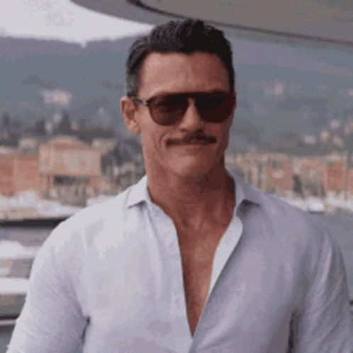 A Man With A Mustache And Sunglasses Is Wearing A White Shirt . GIF