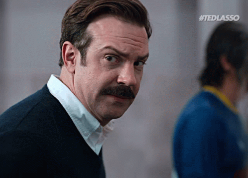 A Man With A Mustache And #Tedlasso Written On The Bottom Right GIF