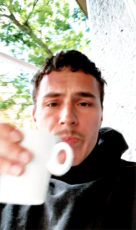 A Man With A Mustache Is Drinking From A White Cup With An O On It GIF