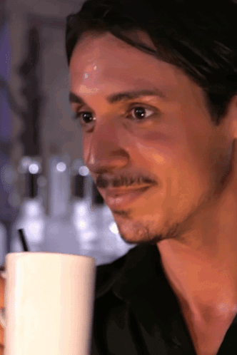 A Man With A Mustache Is Drinking From A White Mug With A Straw GIF