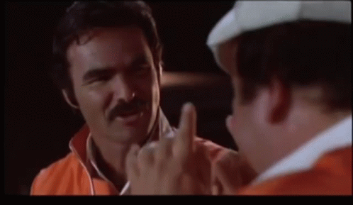 A Man With A Mustache Is Giving The Middle Finger To Another Man GIF