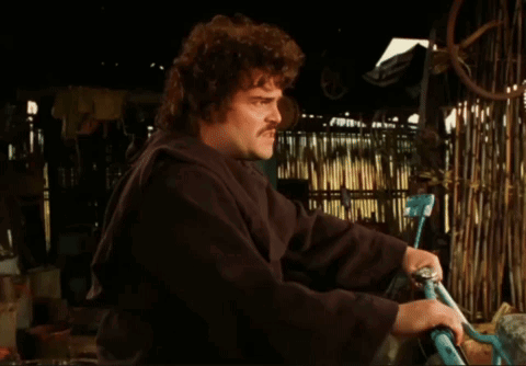 A Man With A Mustache Is Holding A Bicycle In His Hands GIF