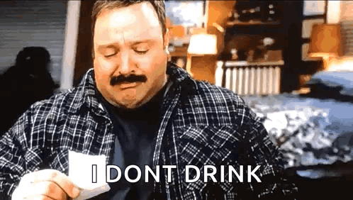 A Man With A Mustache Is Holding A Piece Of Paper And Says I Dont Drink . GIF