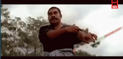 A Man With A Mustache Is Holding A Sword In His Right Hand . GIF