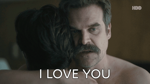 A Man With A Mustache Is Hugging A Woman With The Words I Love You Written Below Him GIF