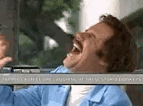 A Man With A Mustache Is Laughing In A Car . GIF