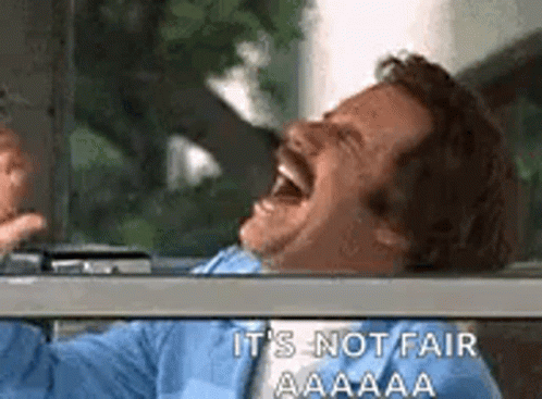 a man with a mustache is laughing in a car .