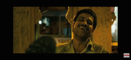 A Man With A Mustache Is Laughing In A Dark Room With Graffiti On The Wall . GIF