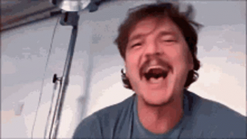 A Man With A Mustache Is Laughing With His Mouth Open GIF