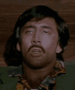 A Man With A Mustache Is Laying Down With His Eyes Closed And His Head Is Visible . GIF