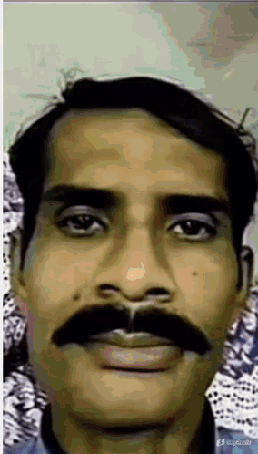 A Man With A Mustache Is Looking At The Camera GIF