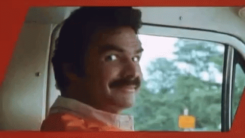 A Man With A Mustache Is Looking Out The Window Of A Car . GIF