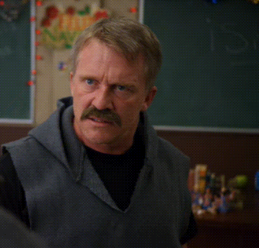 A Man With A Mustache Is Making A Funny Face In Front Of A Sign That Says I Don 'T Get It GIF