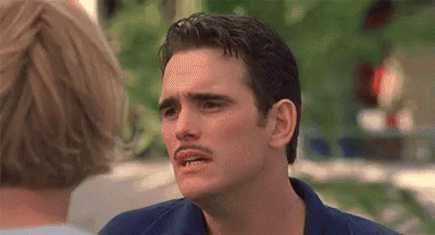 A Man With A Mustache Is Making A Funny Face In Front Of A Woman . GIF
