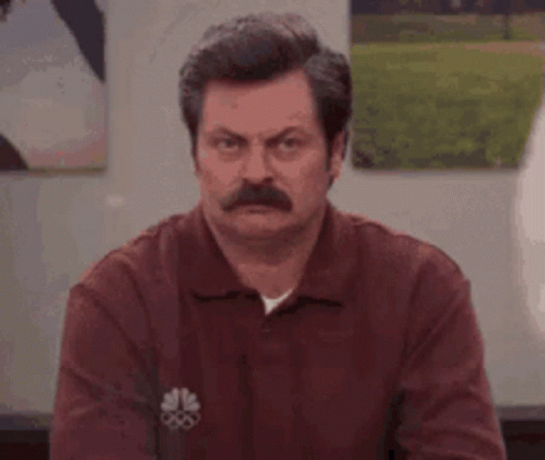 A Man With A Mustache Is Making A Funny Face While Wearing A Red Shirt . GIF
