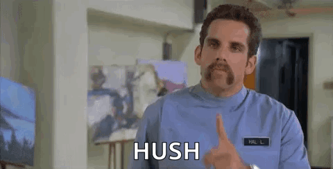 A Man With A Mustache Is Making A Hush Gesture With His Finger To His Mouth . GIF