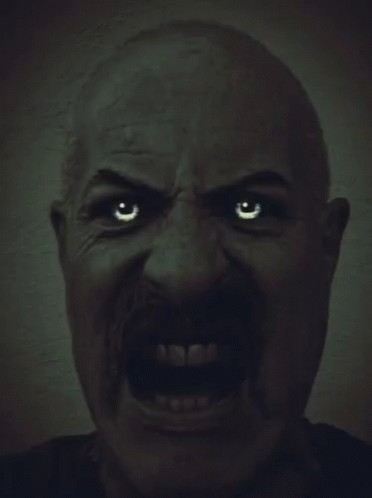 a man with a mustache is making a very angry face