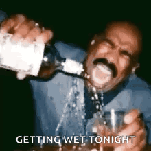 A Man With A Mustache Is Pouring A Drink Into A Glass . GIF