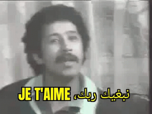 A Man With A Mustache Is Singing A Song In A Black And White Video . GIF