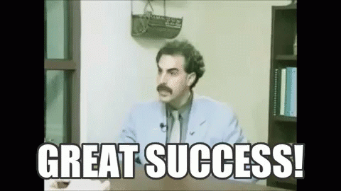 A Man With A Mustache Is Sitting At A Desk With The Words `` Great Success '' Written Above Him . GIF